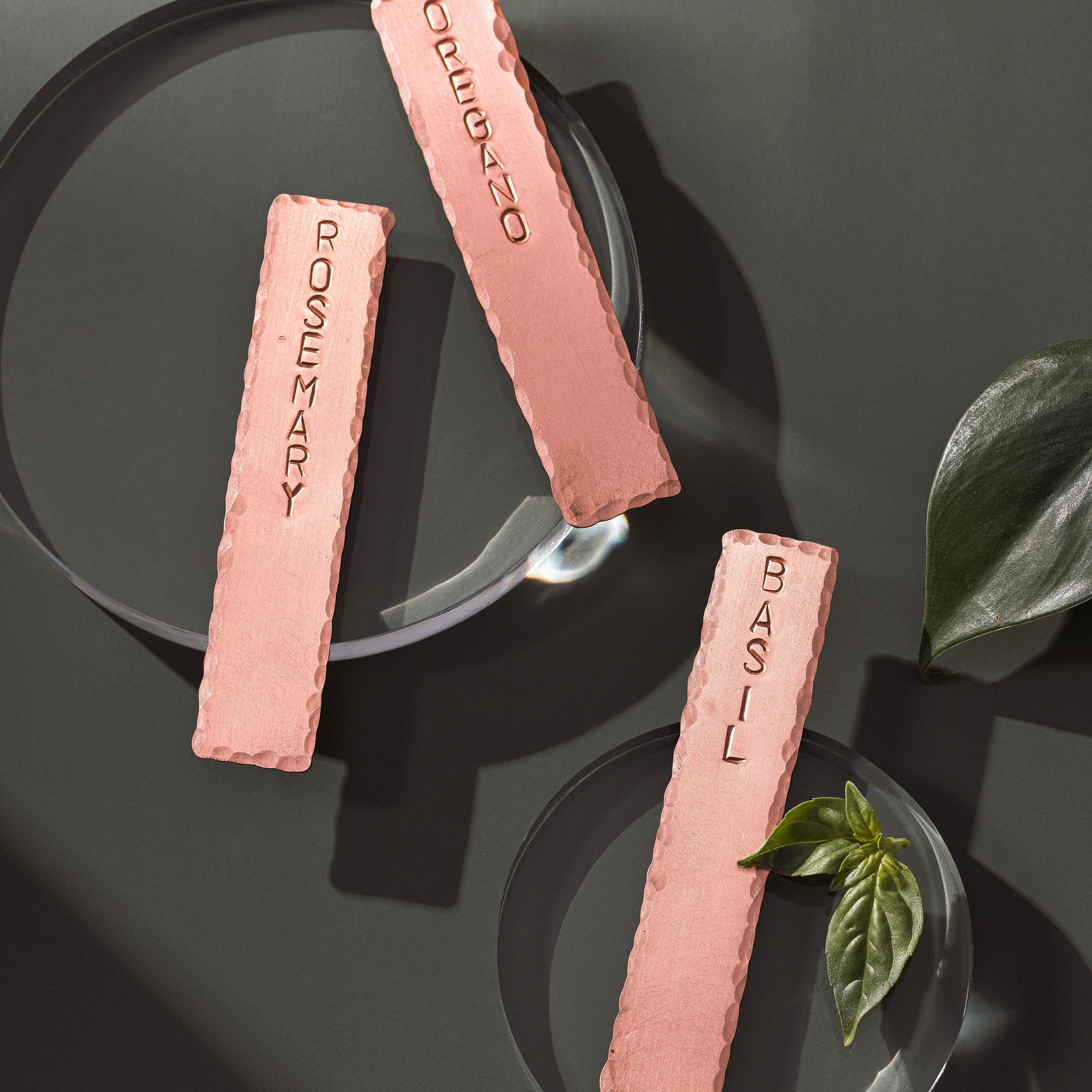 A set of three, garden herb tags. The tags are made from copper and are engraved: Oregano, Rosemary and Basil. The tags are made in Perth by Empire Copper.